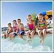 Children sitting at a swimming pool