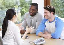 MSM couple sitting at a desk and talking with a clinician