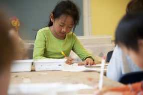 A young girl studying at a school desk