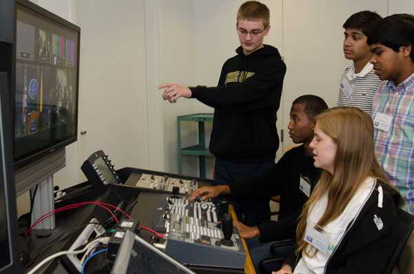 Students work behind the scenes to make sure the press conference runs smoothly.