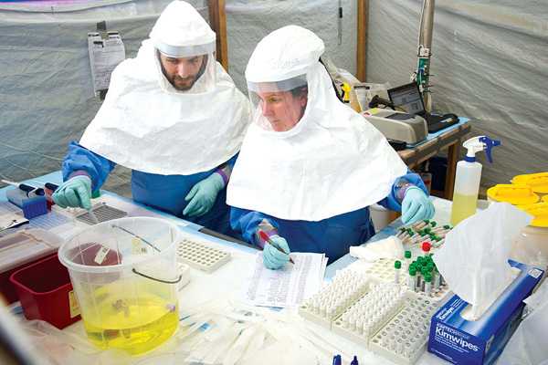 At the CDC lab in Bo, Sierra Leone, 53 CDC laboratorians working in teams of four tested 26,254 samples for 406 days straight. Here CDC laboratorians test blood samples for Ebola in the hot lab in Bo, Sierra Leone. Photo by David Snyder, courtesy of the CDC Foundation