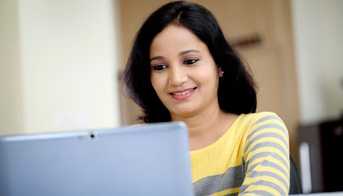 Girl sitting at a laptop computer.