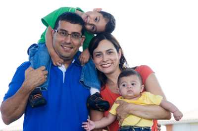 Mom holding baby. Dad with toddler on his back.