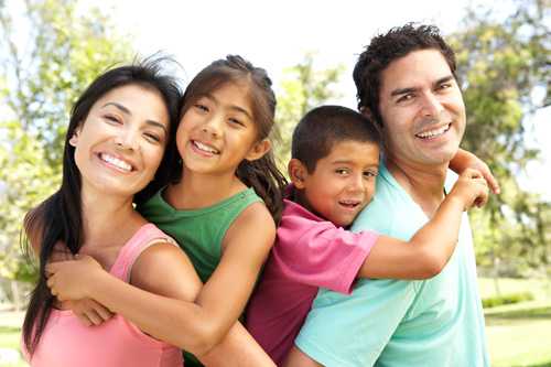 Family posing for a picture in a park.