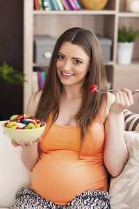 Pregnant woman eating fruit salad