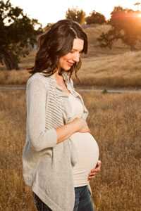 Pregnant woman walking in a field.