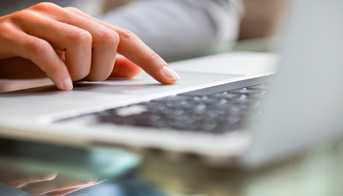 Closeup of a woman typing on a laptop