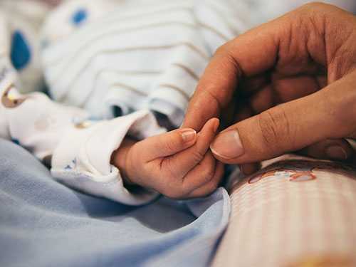 Mother holding her baby's hand