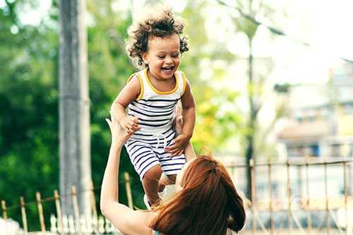 A mother holding a happy child up