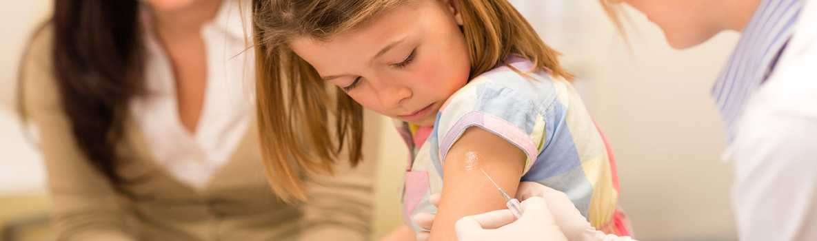 Elementary school girl getting a flu shot.