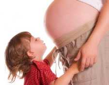 Boy standing in front of his pregnant mother