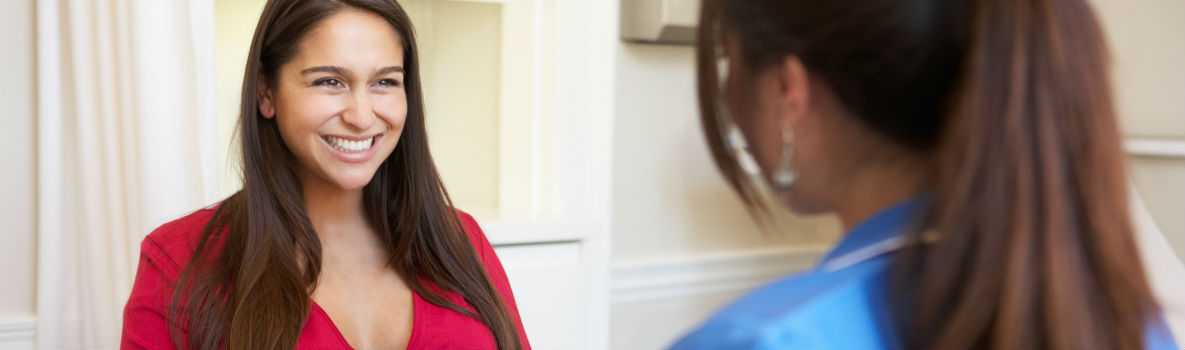 Photo of pregnant woman having a discussion with her female doctor