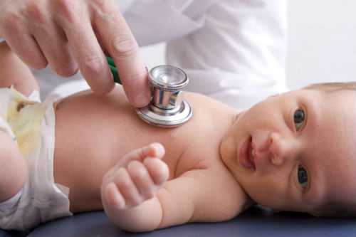 Photo of doctor listening to newborn baby's heart with a stethoscope