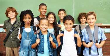 Kids standing in front of a chalkboard.