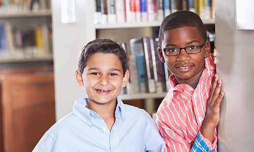 Two smiling boys in the library