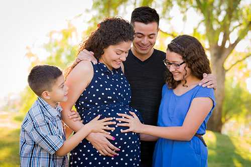 	Una mujer embarazada y su familia 