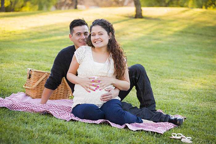 Pareja hispana embarazada en el parque