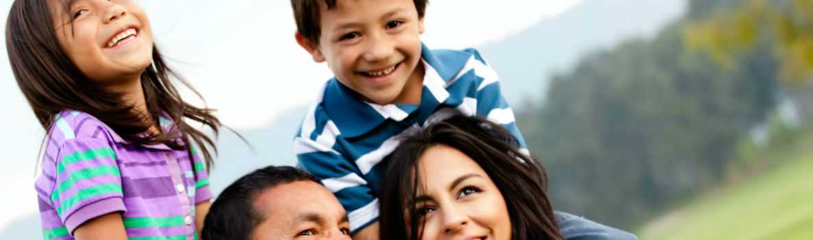 Photo of Hispanic parents holding up children on their shoulders