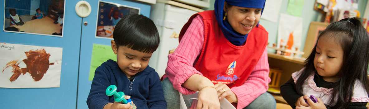 Children playing while their caregiver watches