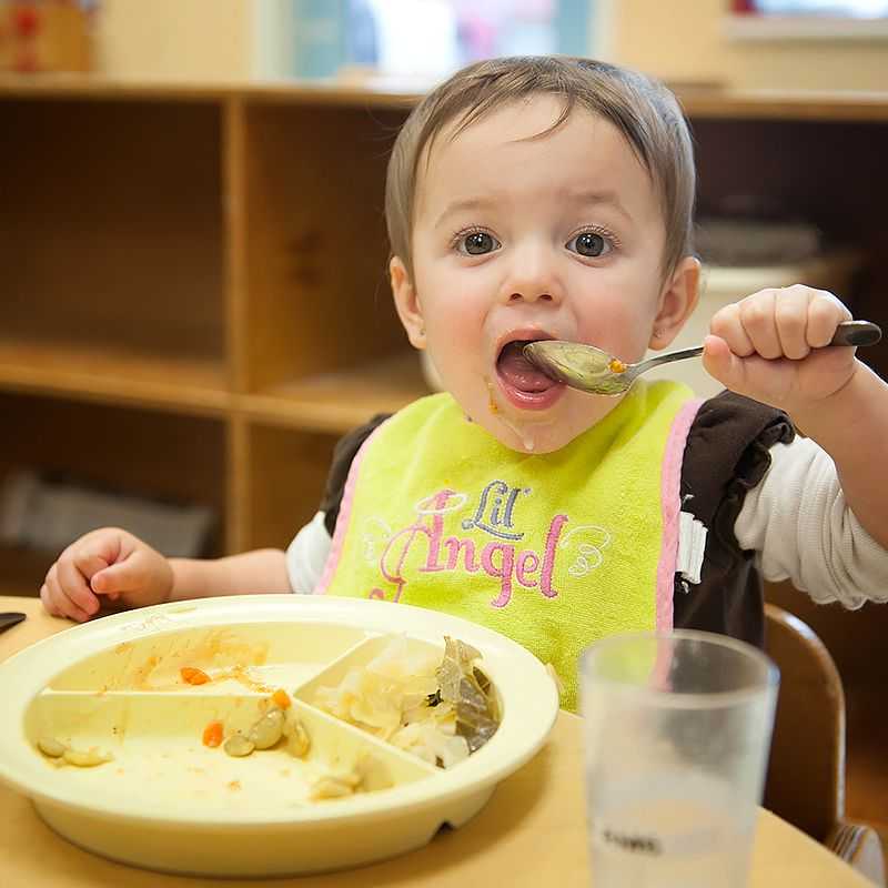 A child eats with a spoon.