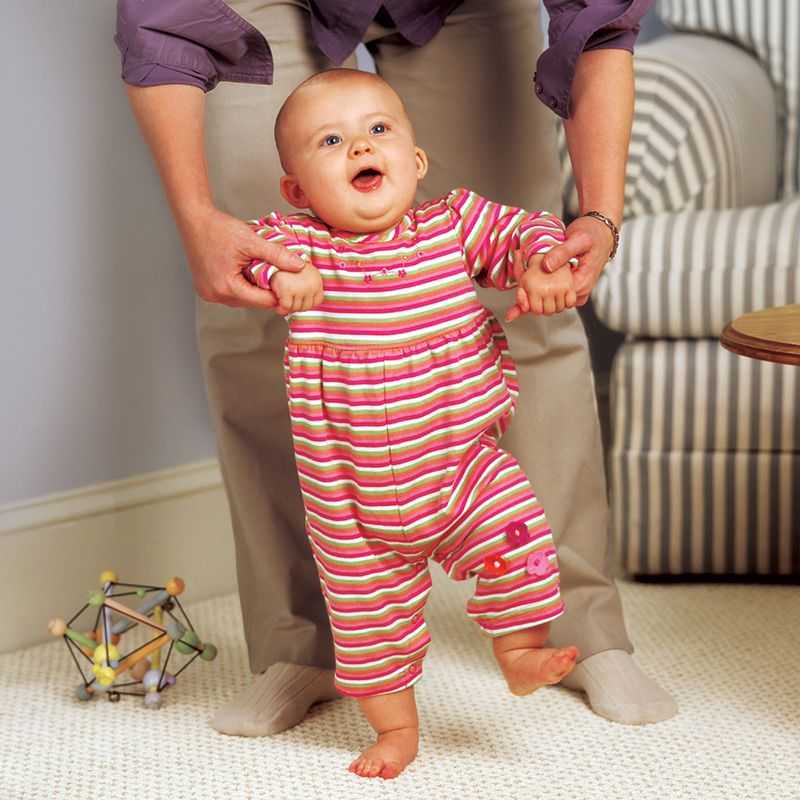 A mother helps her child learn to walk.