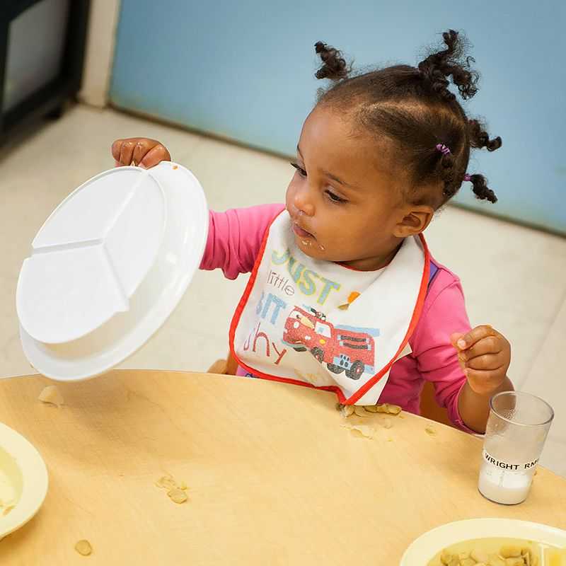 Una  niña pequeña da vuelta su plato.