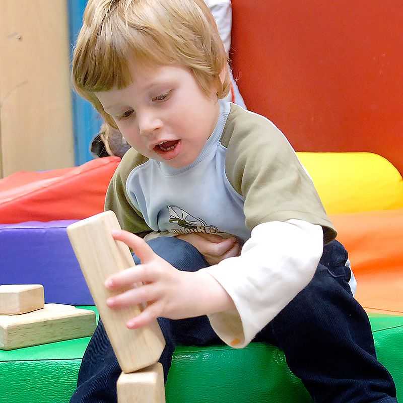 Un niño arma una torre de bloques.