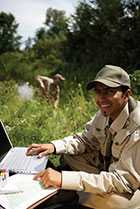 Image of a uniformed worker taking samples in the field