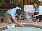 Photo shows people taking water samples from a hot tub.