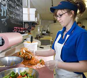 Photo of food worker preparing raw foods.