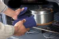 Photo of chef removing pot from oven.