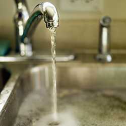  Water flows from faucet at kitchen sink.