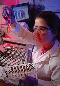 Lab technician examining a test tube.