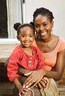 Mother and daughter sitting on the steps outside their house