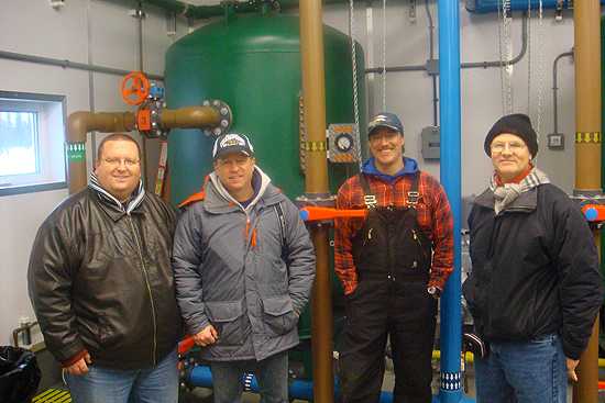 Martin Kalis, CAPT Mike Herring, Samuel Lee Bartels (environmental health practitioner, Tyonek, AK), and CAPT Mark Miller visiting the water treatment facility in Tyonek, AK