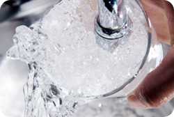 Filling a glass of ice at a faucet