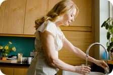 Woman drinking glass of water from tap