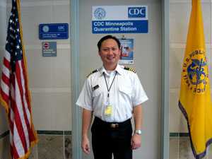 Arnold Vang standing next to two flags.