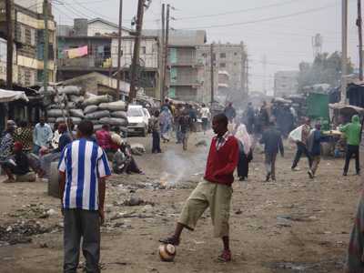 Men kicking a ball in the street