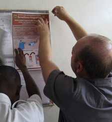 Two men hanging a poster on a wall