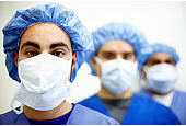 Healthcare workers in scrubs, all wearing masks..