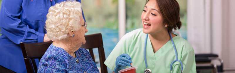 An older female patient discusses her condition with her medical professional