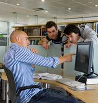 	Three men view information together at a computer