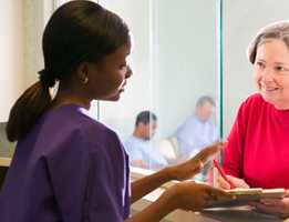 Health worker talking to a patient at a facility check-in desk