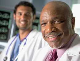 Two doctors looking at the camera and smiling