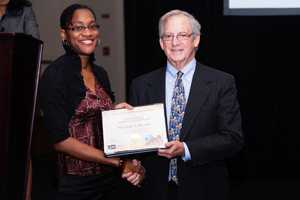 Monique Brown receives the first place student poster prize from NCHS Director Edward Sondik.