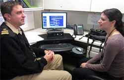 photo of Chad Cox speaking with Ruth Link-Gelles at computer desk