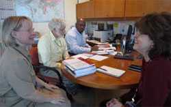 photo of group sitting at computer desk