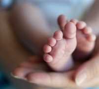 Photo of mother holding infant's foot