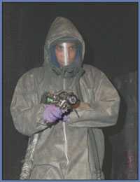 Worker wearing face mask, protective suit and gloves.